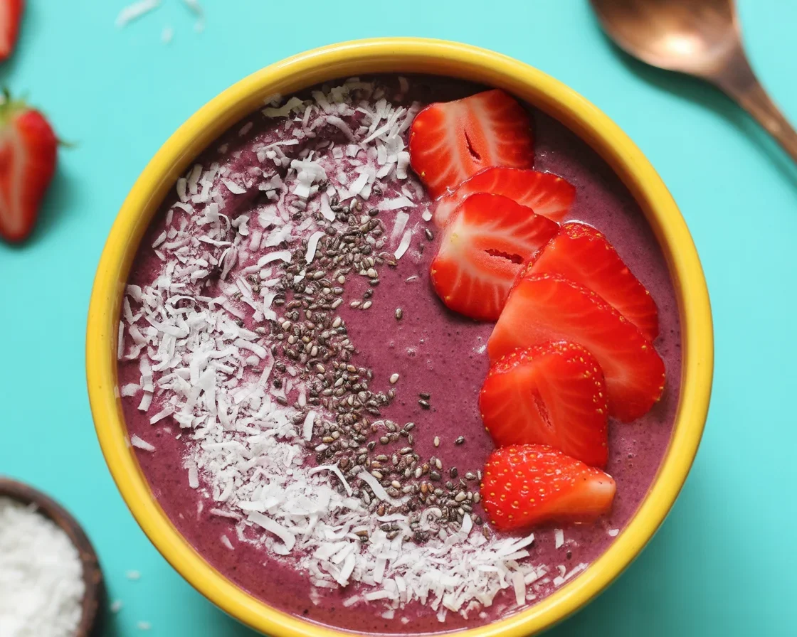 Colorful smoothie bowl topped with fruits and seeds for a healthy breakfast.