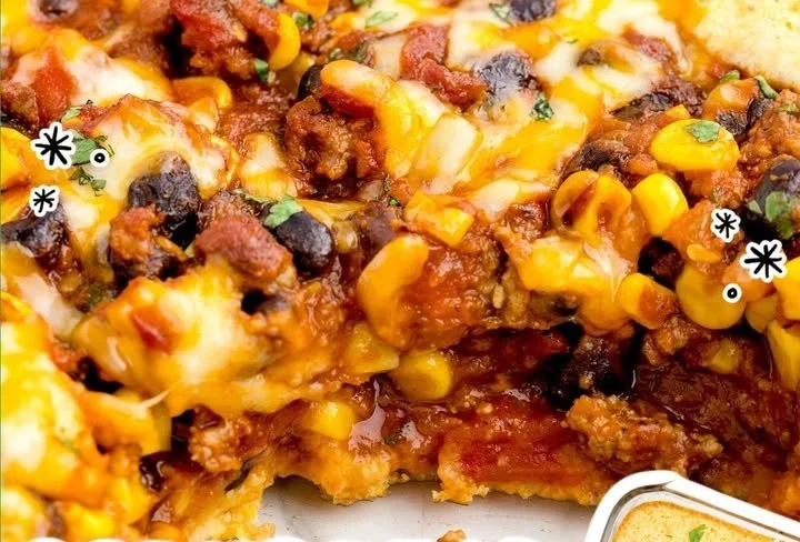 Delicious Chili Cornbread Bake topped with cheese and served in a rustic dish.