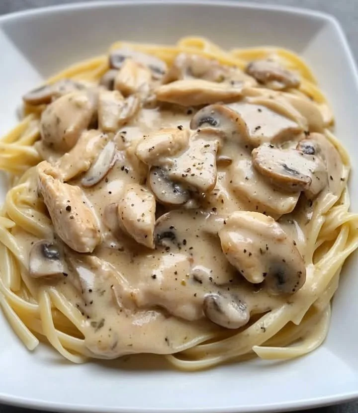 Creamy chicken pasta dish garnished with parsley and served in a bowl