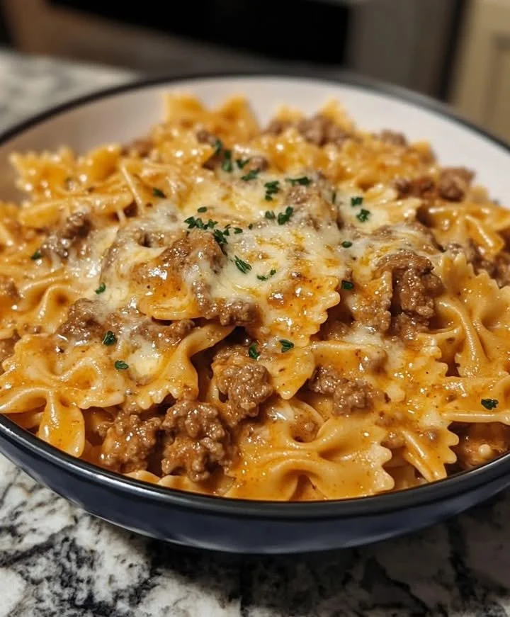 Creamy garlic pasta dish garnished with herbs in a bowl.