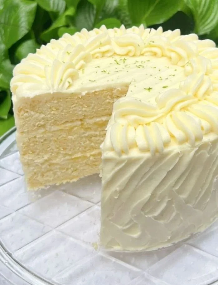 Lime Velvet Cake topped with lime zest and frosting, showcasing its vibrant green color.
