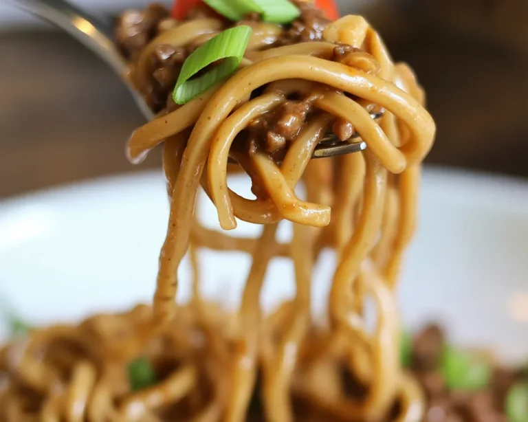 Delicious Mongolian Ground Beef Noodles served with fresh vegetables and a savory sauce.