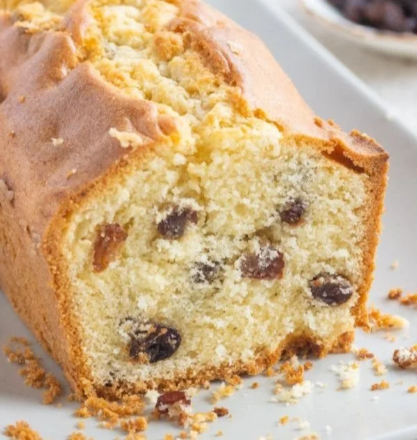 Delicious homemade raisin cake on a white plate with fresh raisins.