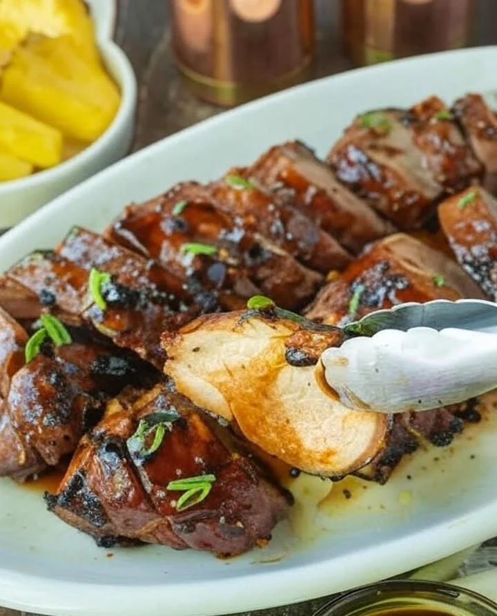 Delicious teriyaki grilled pork garnished with green onions on a plate.