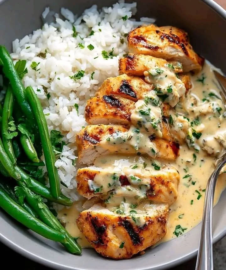 Delicious grilled chicken bowl garnished with fresh vegetables and sauce.