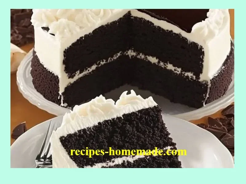 A slice of rich and moist Black Velvet Cake on a white plate with a fork.