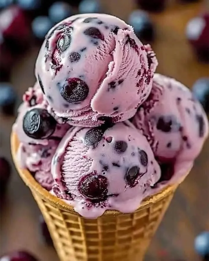 Delicious homemade blueberry ice cream in a bowl with fresh blueberries
