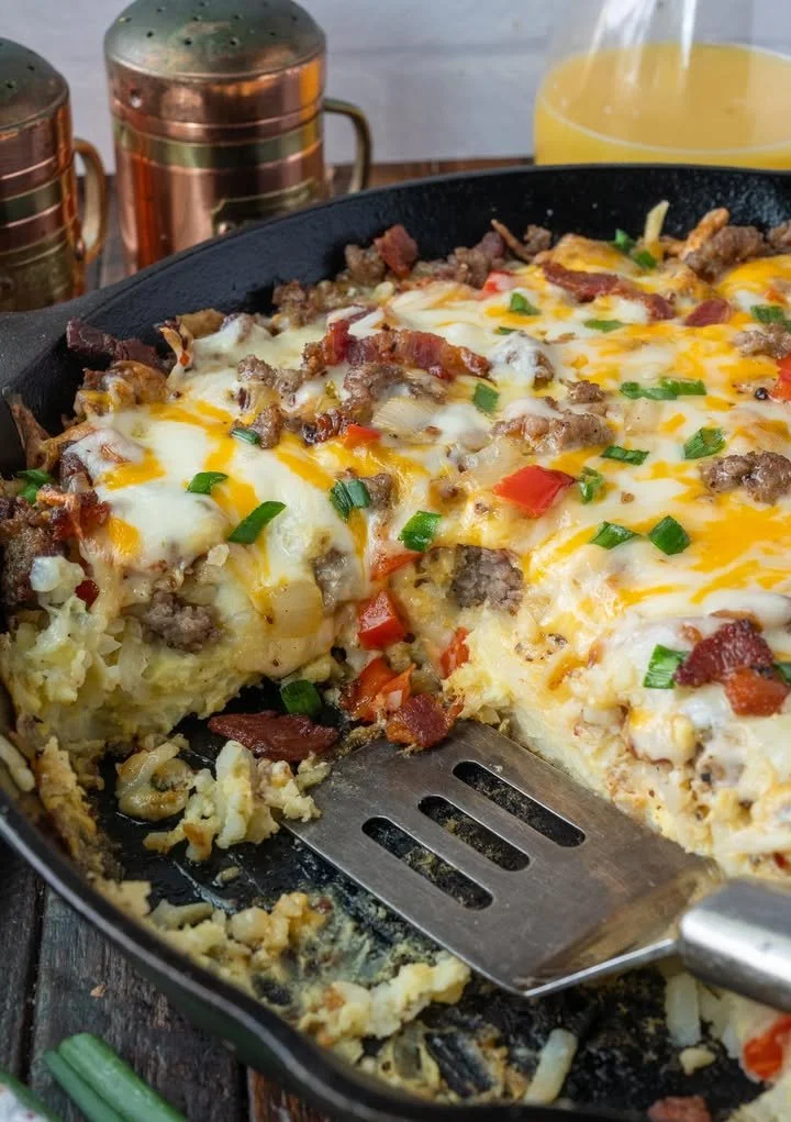 Delicious breakfast casserole served on a plate with fresh herbs on top.
