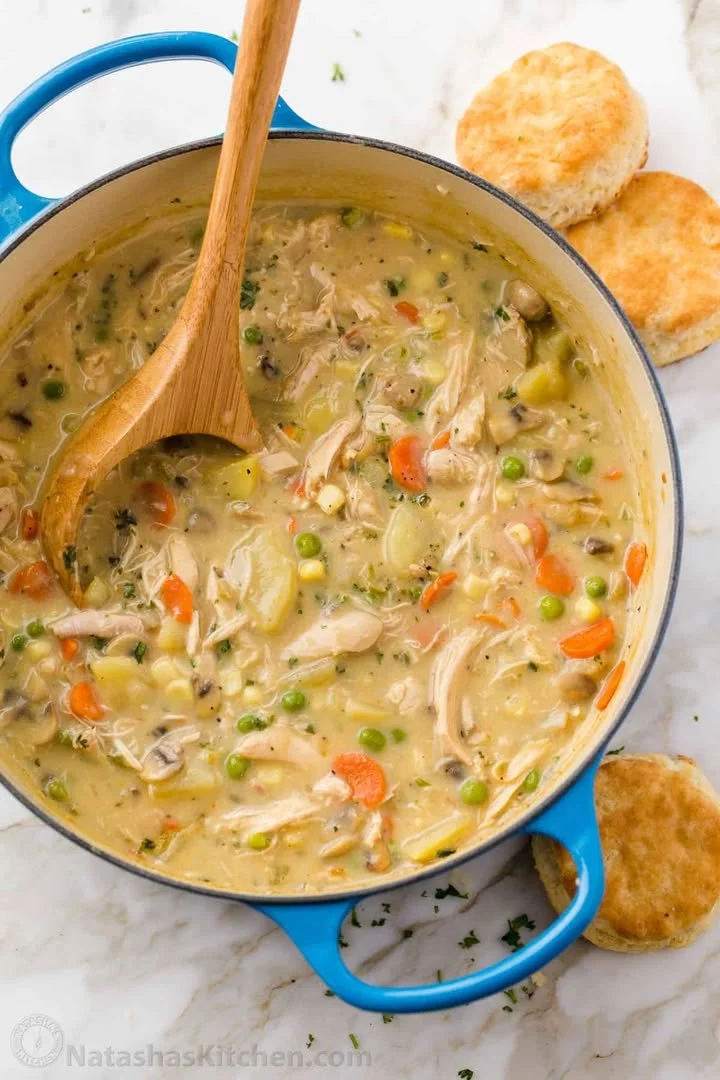 Bowl of creamy Chicken Pot Pie Soup with vegetables and biscuits