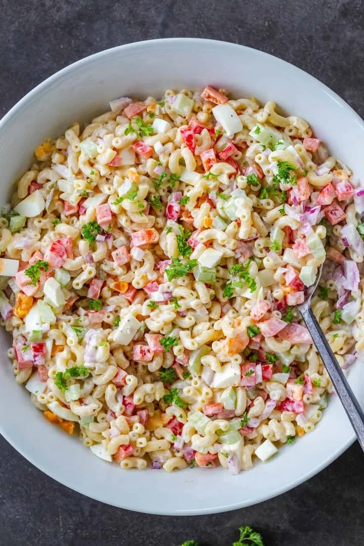 Cool Creamy Pasta Salad served in a bowl with fresh vegetables and herbs