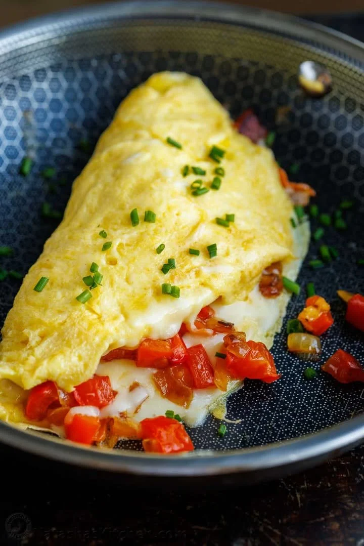 Delicious fluffy omelette garnished with herbs and served on a plate