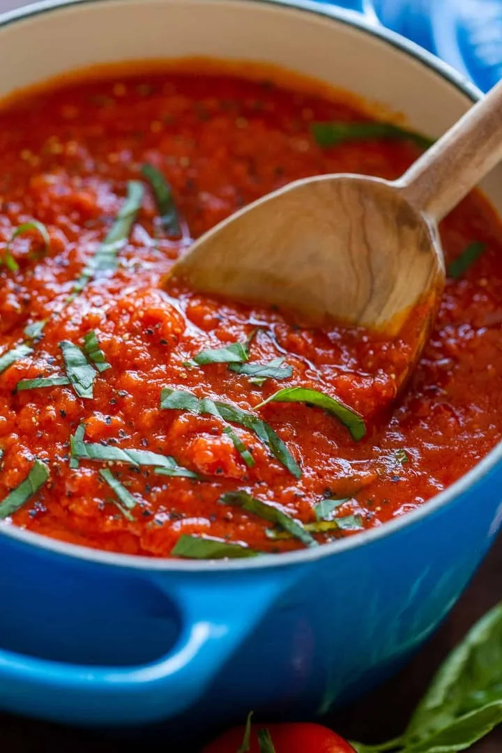 Bowl of homemade marinara sauce with fresh tomatoes and herbs
