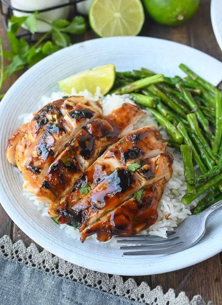 Honey Sriracha Grilled Chicken on a serving plate garnished with fresh herbs.