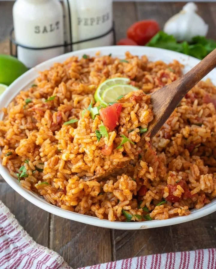 A vibrant bowl of homemade Mexican rice garnished with cilantro and lime