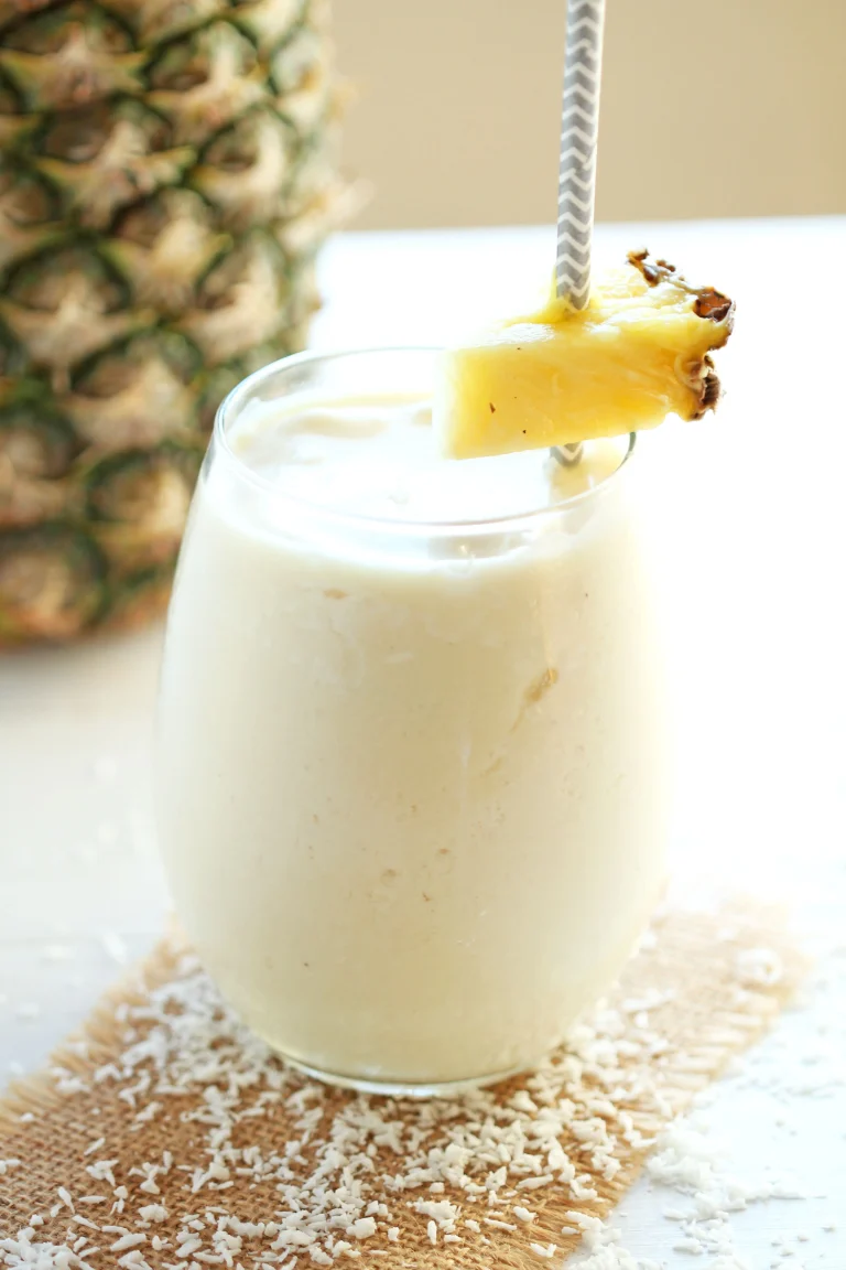 Delicious pineapple coconut smoothie in a glass with fresh fruit
