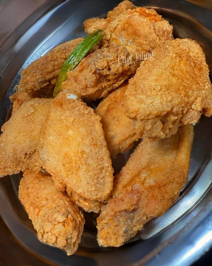 Fried chicken garnished with green onion and bell pepper for enhanced flavor