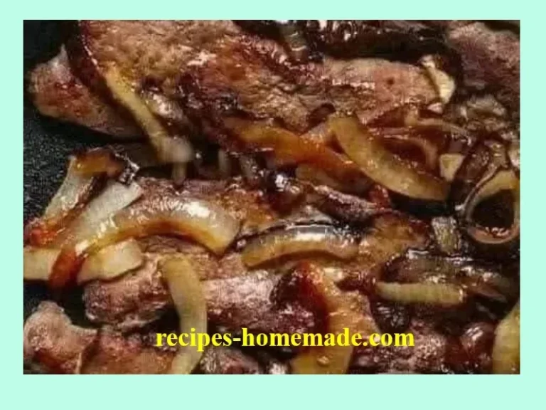 Plate of beef liver and onions garnished with herbs.