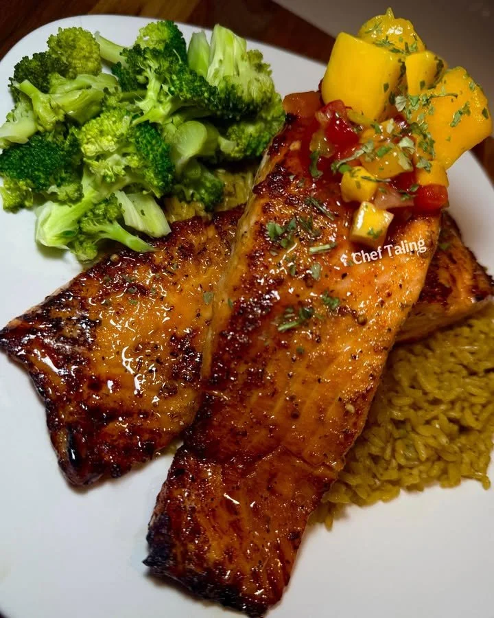 Broiled honey garlic butter salmon served with mango salsa on a plate.