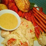 Delicious butter and herb roasted lobster on a plate, garnished and ready to serve.