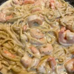 Creamy shrimp alfredo pasta dish served with fresh herbs