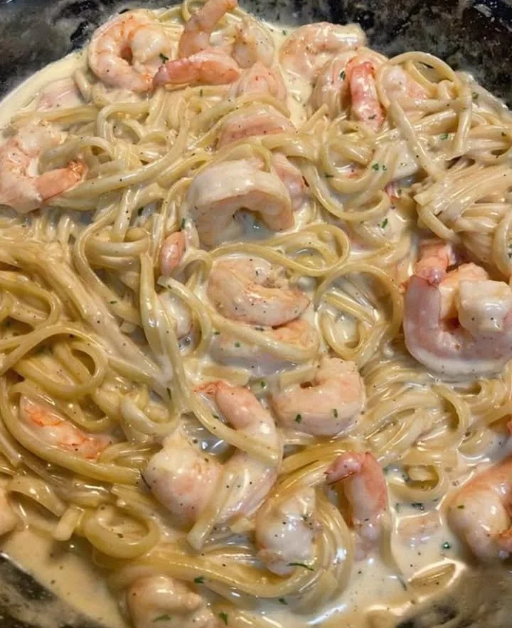 Creamy shrimp alfredo pasta dish served with fresh herbs