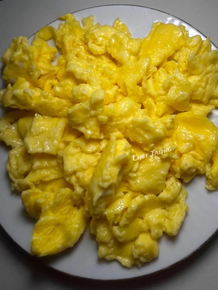 Fluffy buttery scrambled eggs with cheese served on a plate