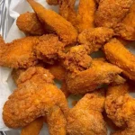 Crispy, golden fried chicken on a plate served with dipping sauce