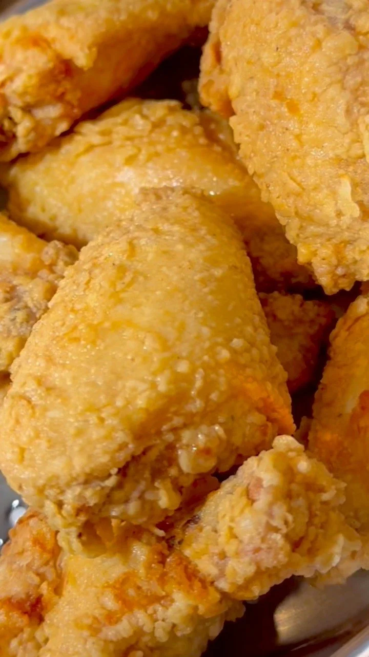 Plate of golden, crispy fried chicken served with sides.