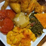 Fried chicken served with herb dressing and chicken gravy on a white plate