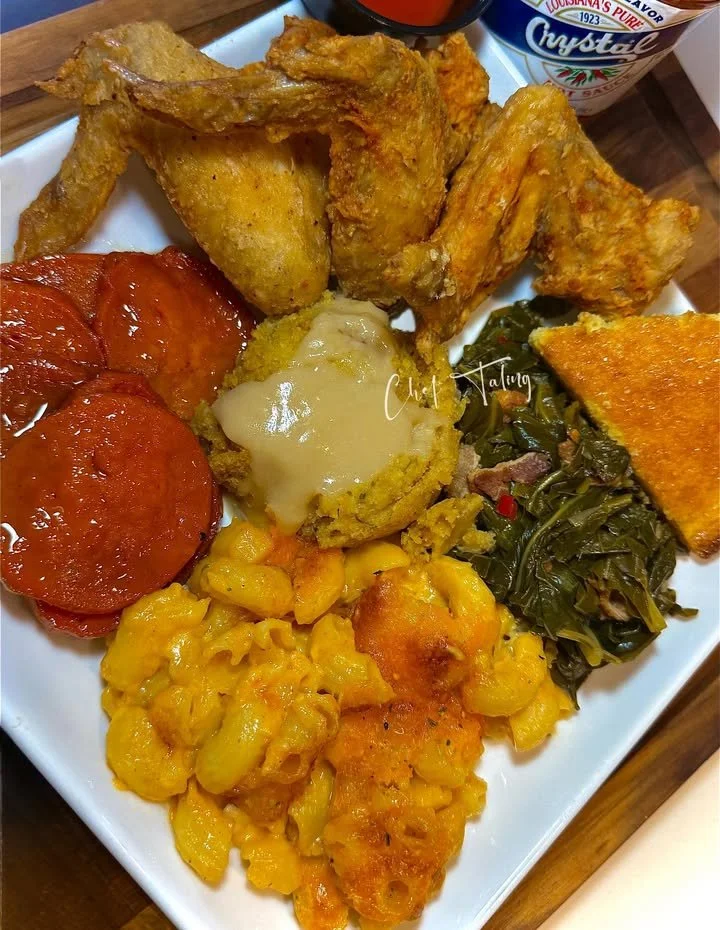 Fried chicken served with herb dressing and chicken gravy on a white plate