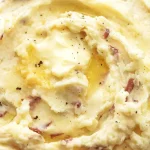 Delicious garlic mashed potatoes on a plate with garnishing