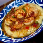 Lite Cowboy Butter Shrimp served with creamy grits on a plate