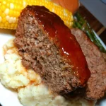 Deliciously baked meatloaf served with mashed potatoes and garnish.