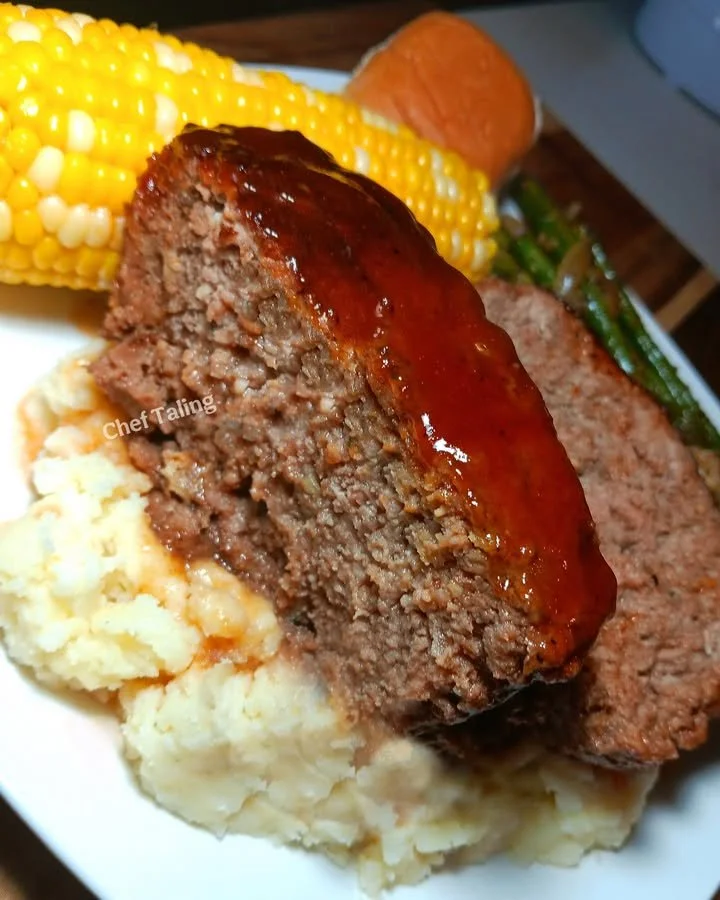 Deliciously baked meatloaf served with mashed potatoes and garnish.