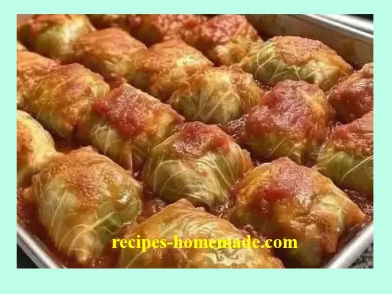 Homemade old-fashioned stuffed cabbage rolls on a plate with tomato sauce.