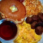Pancakes served with Italian sausage balls for a hearty breakfast.