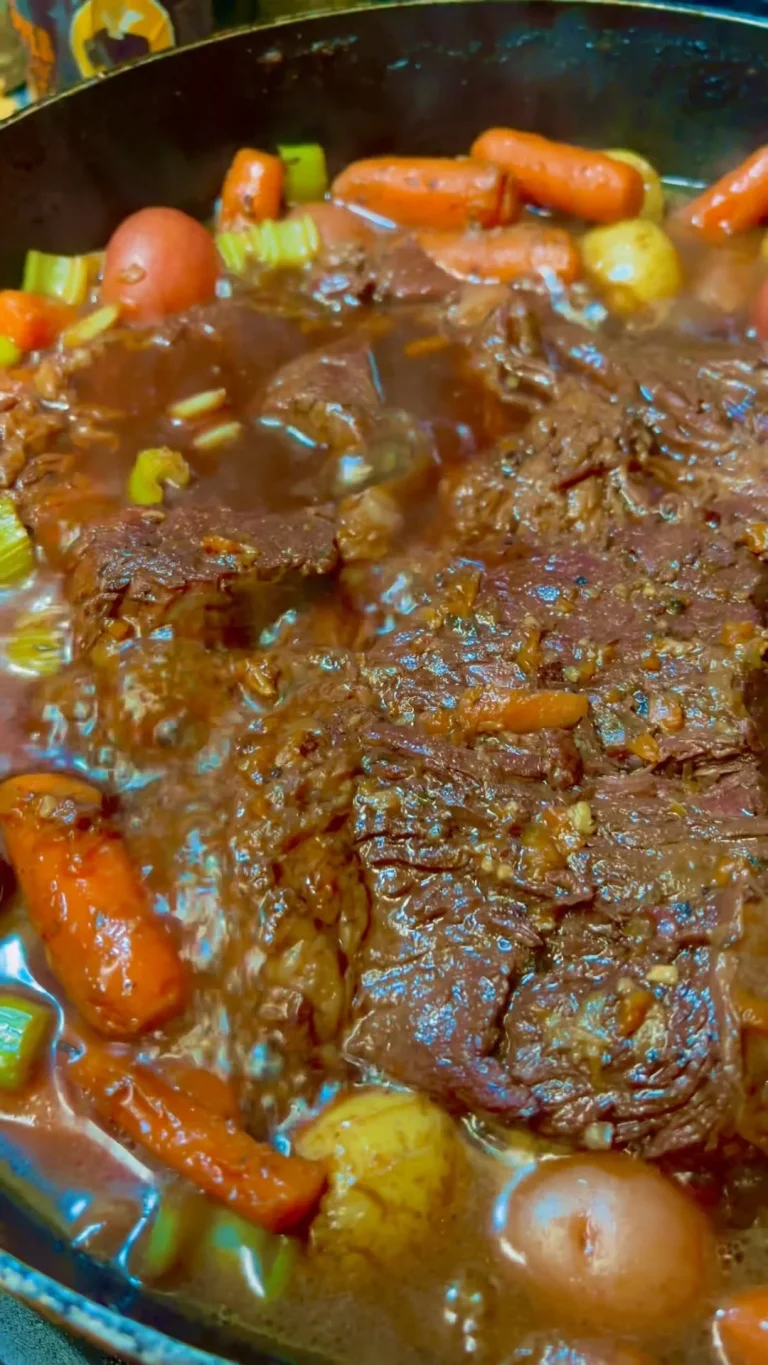 Delicious pot roast served with vegetables and gravy on a dinner plate