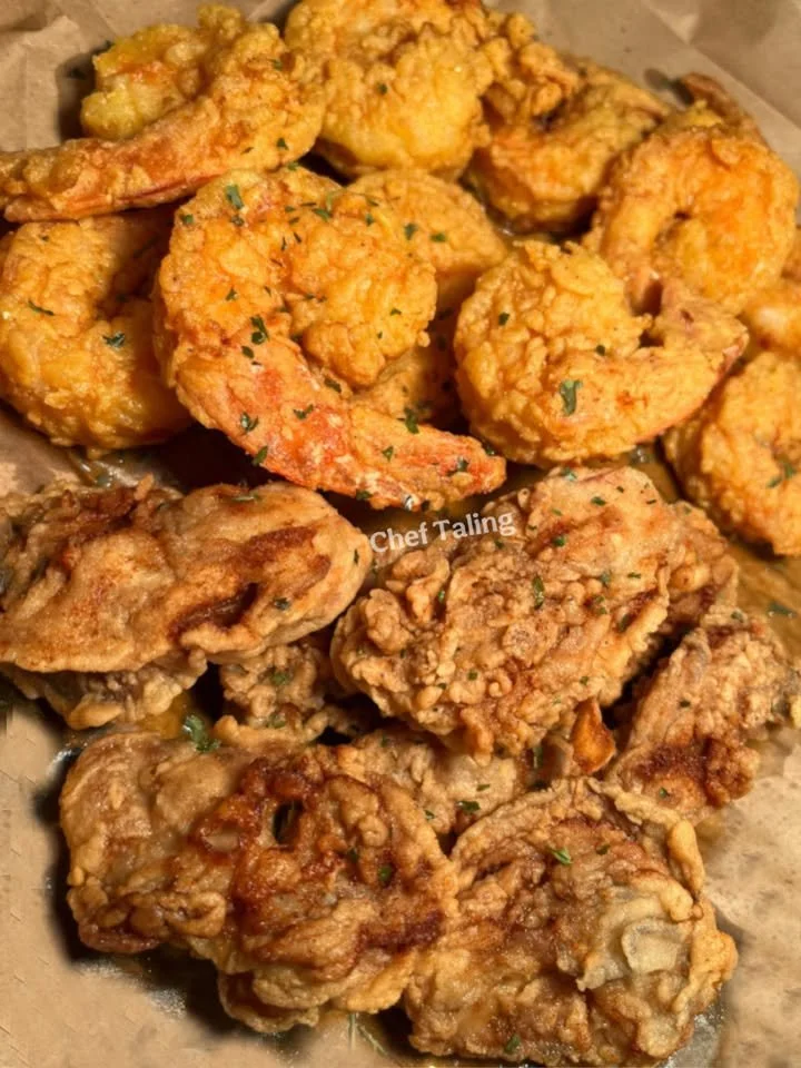 Plate of shrimp and oysters served with lemon and cocktail sauce.