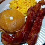 Silver Dollar Pancakes served with bacon and scrambled eggs on a plate
