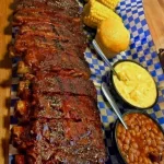 Delicious smoked barbecue ribs served on a rustic wooden platter.