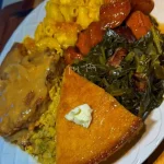 Plate of smothered pork chops in savory sauce garnished with herbs