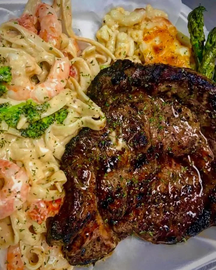 Delicious Steak and Shrimp Alfredo with creamy sauce and garnishes