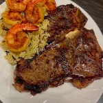 Delicious plate of Steak & Honey Shrimp over garlic butter wild rice