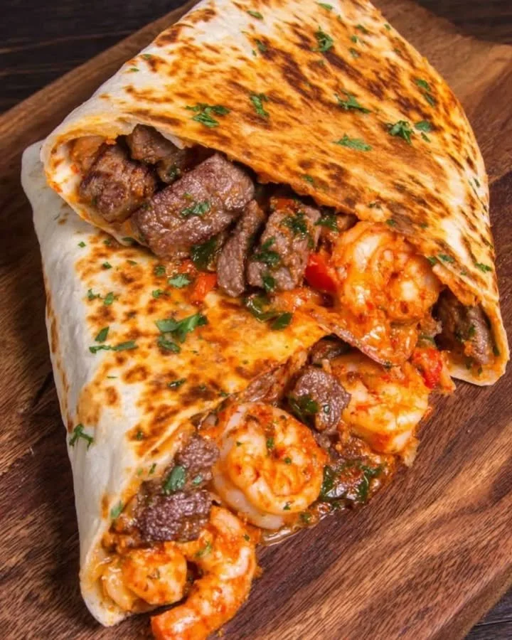 Delicious Steak & Shrimp Quesadilla served with melted cheese and fresh toppings