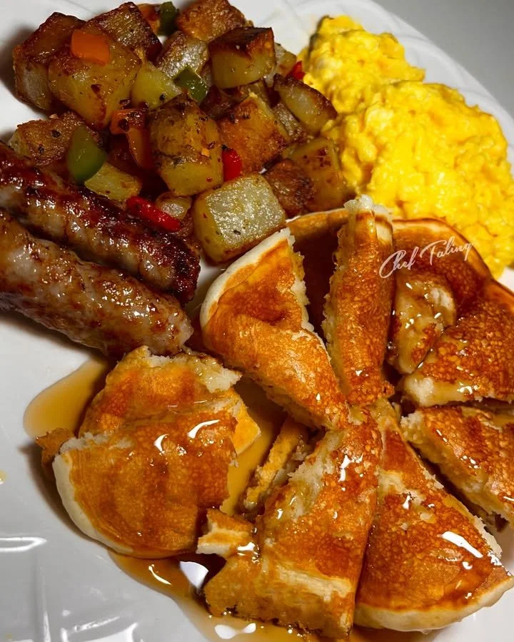 Delicious Sunday breakfast spread with pancakes, eggs, and fresh fruits.