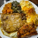 A vibrant plate of soul food featuring fried chicken, collard greens, and cornbread.