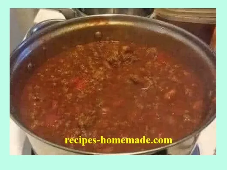 Wendy's copycat chili prepared in a slow cooker, garnished with cheese and onions.