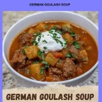 Bowl of German Goulash Soup garnished with fresh herbs and bread