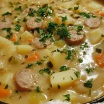 Bowl of creamy potato soup topped with herbs and spices