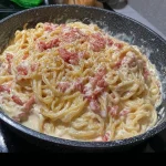Delicious Carbonara Pasta garnished with cheese and parsley on a plate